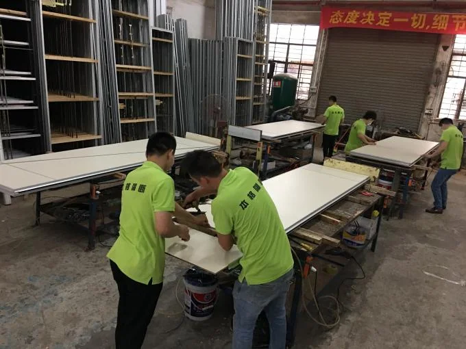 Workers assembling movable partition wall panels in the workshop